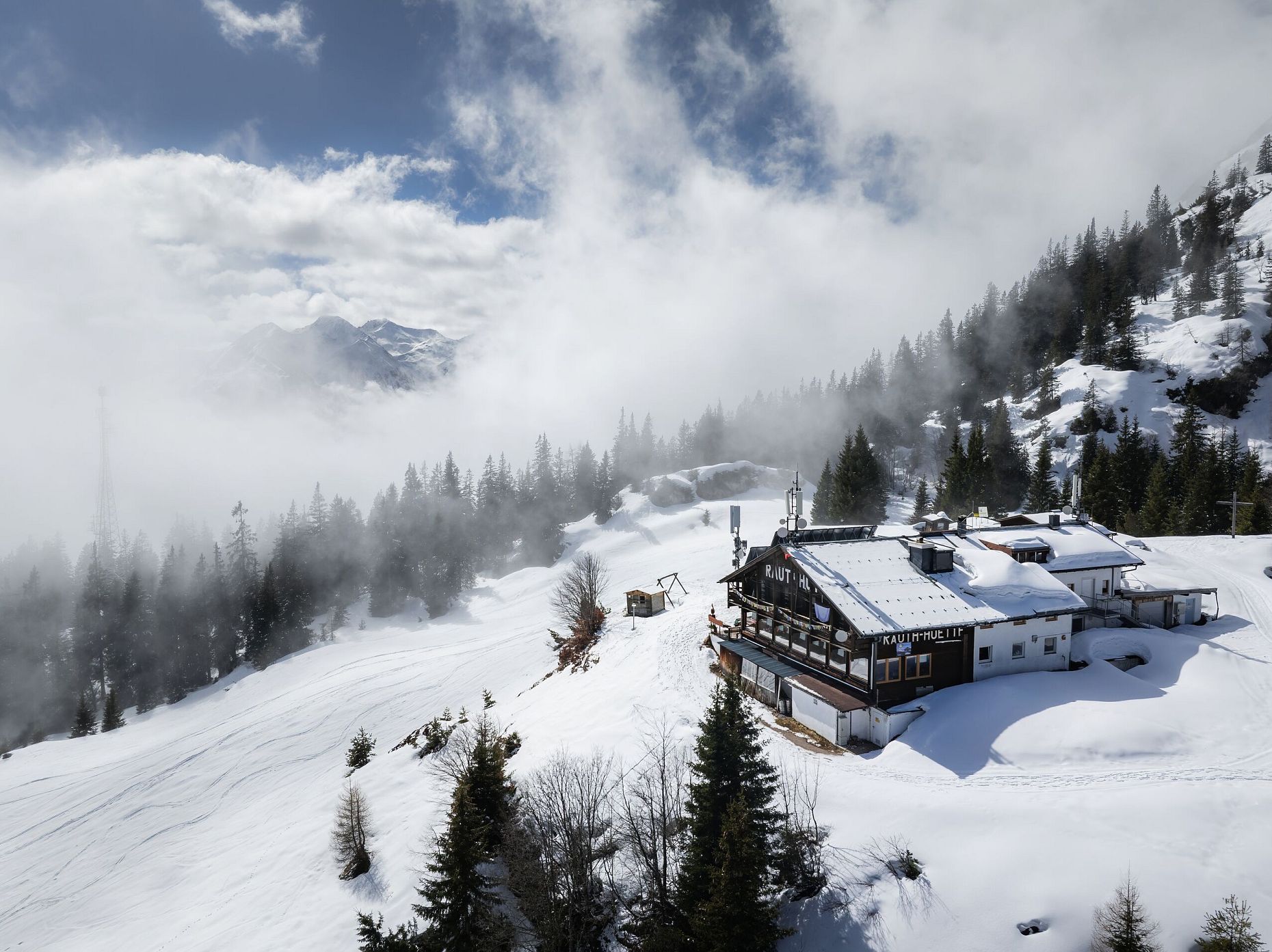 Drohnenaufnahme Rauthhütte - Hütte von der Seite mit nebeligem Inntal