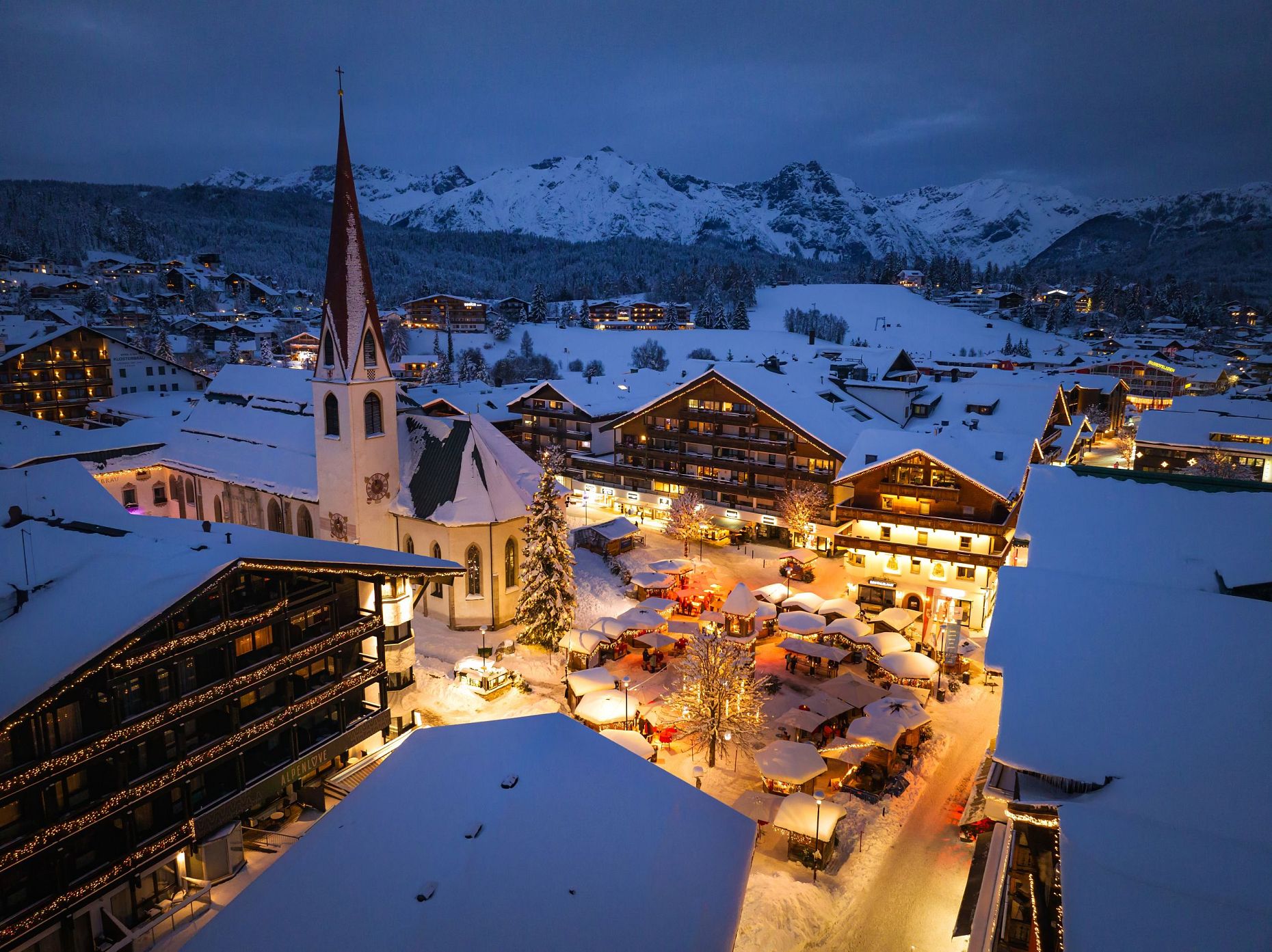 Drohnenaufnahme Weihnachtsmarkt bei Dämmerung Nahaufnahme Richtung Wettersteingebirge