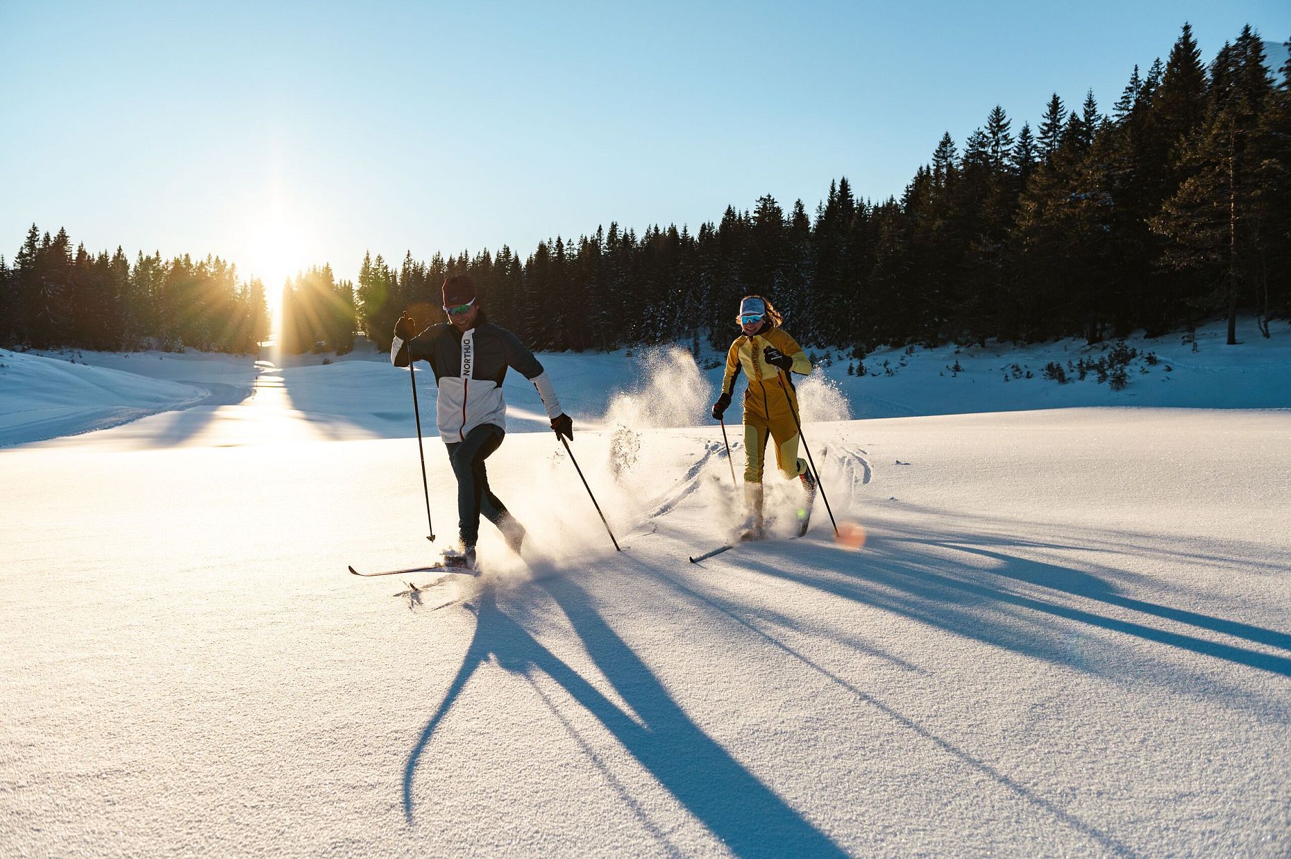 Zwei Langläufer in der Region Seefeld bei Sonnenschein im Schnee.