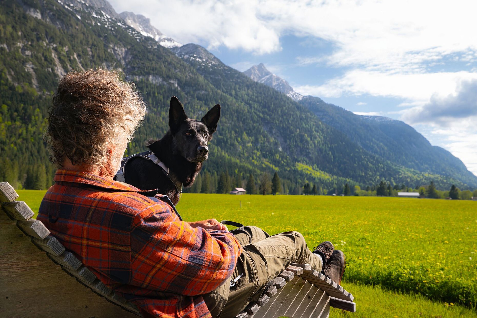 Spaziergang mit Hund in Unterleutasch - Potraitaufnahme Mann mit Hund auf Liege