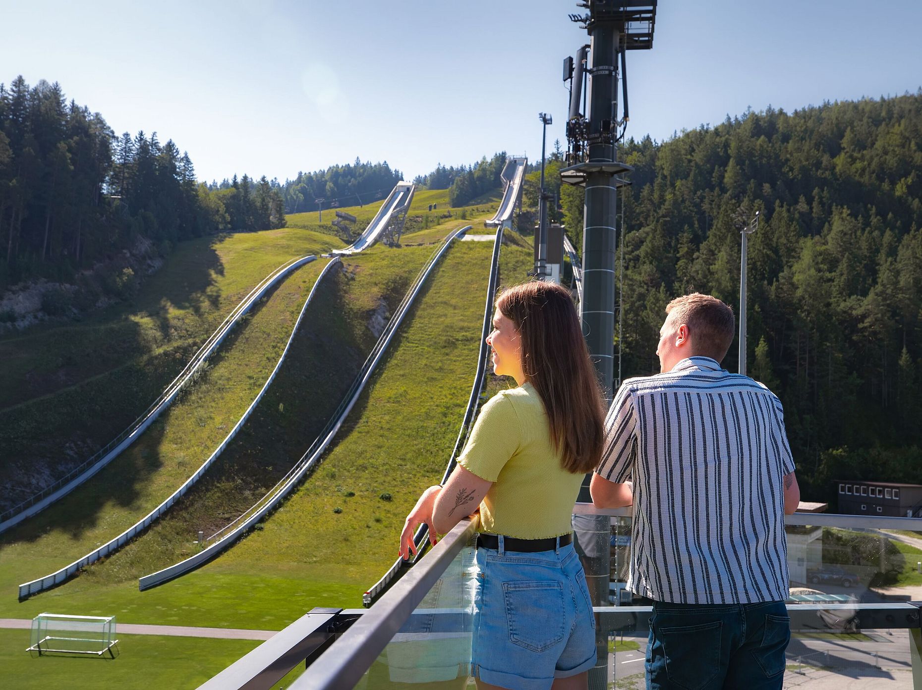 WM Arena im Sommer_Paar steht auf Aussichtsturm und blickt zur Schanze