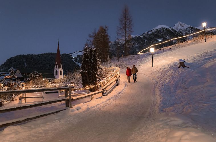 Winterlicher Abendspaziergang in der Region Seefeld mit Kirche und Bergpanorama.