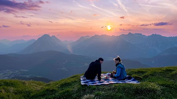 slider-ein-paar-sitzt-beim-sundowner-picknick-mit-blick-richtung-leutasch-1