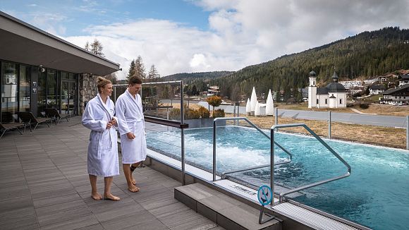 slider-olympiabad-seefeld-paar-steht-bei-outdoorpool-im-wellnessbereich-1