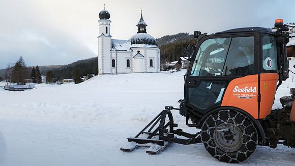 Chapel in the Region Seefeld with snow grooming vehicle in foreground.