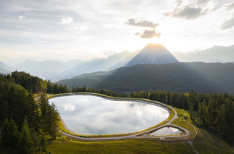 drohnenaufnahme-gschwandkopf-speichersee-mit-hohe-munde-im-hintergrund-bei-sonnenuntergang-2