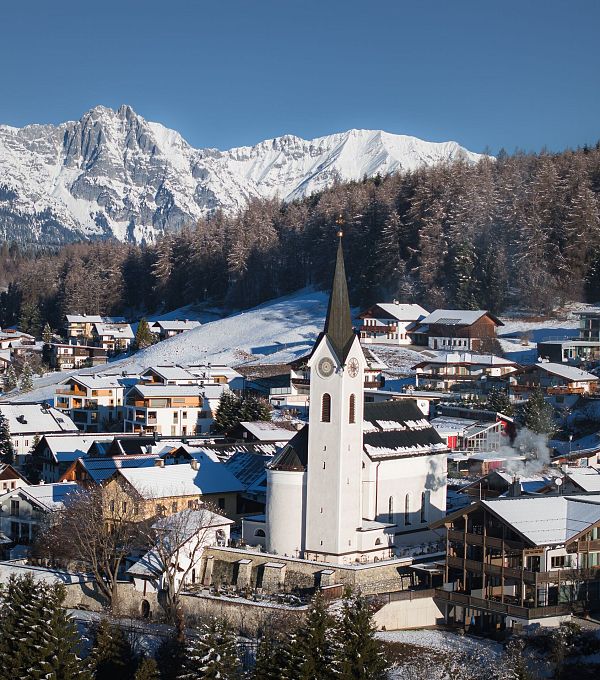 drohnenaufnahme-reith-im-winter-kirche-reingezoomt-mit-wettersteingebirge-im-hintergrund-5