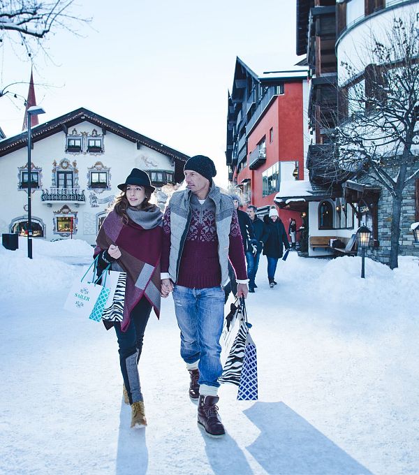 Pärchen mit Einkaufstüten in der verschneiten Region Seefeld.