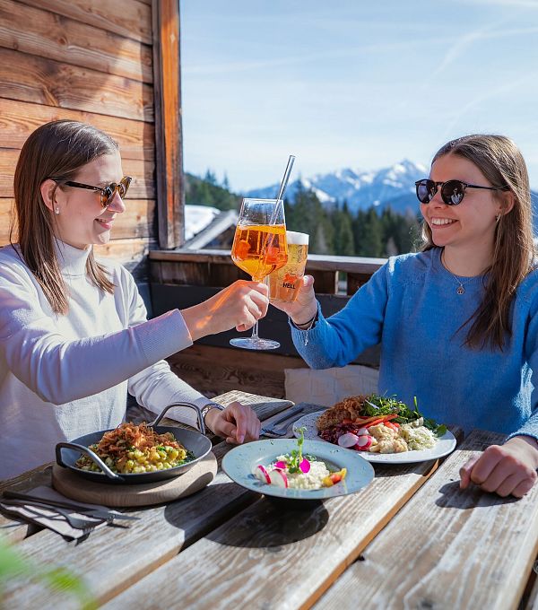 Einkehr auf der Hämmermoosalm im Winter_zwei Frauen stoßen an