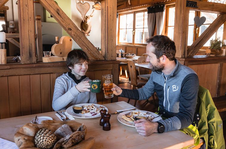 Einkehr beim Skifahren - Vater und Sohn auf der Hütte