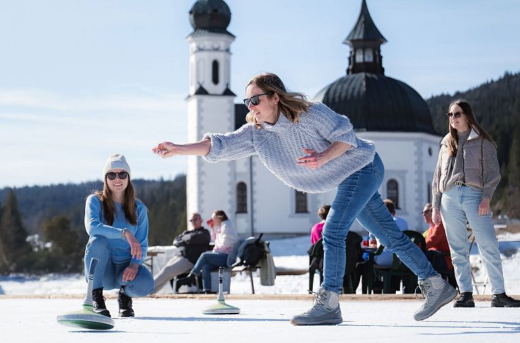 Eisstockschießen am Eislaufplatz in Seefeld_Frau im Wurf_Hochformat