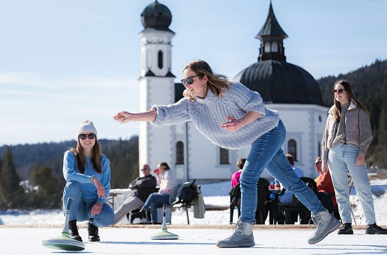 Eisstockschießen am Eislaufplatz in Seefeld_Frau im Wurf_Hochformat