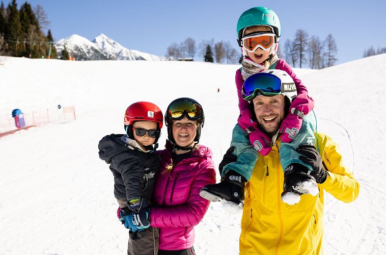Familie beim Skifahren in der Region Seefeld, fröhlich in bunter Winterkleidung im Schnee. Winterurlaubsspaß mit Kindern.