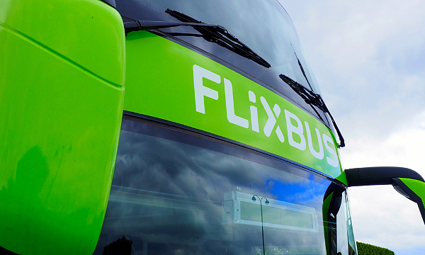 Nahaufnahme eines grünen FlixBus mit großen Fenstern.