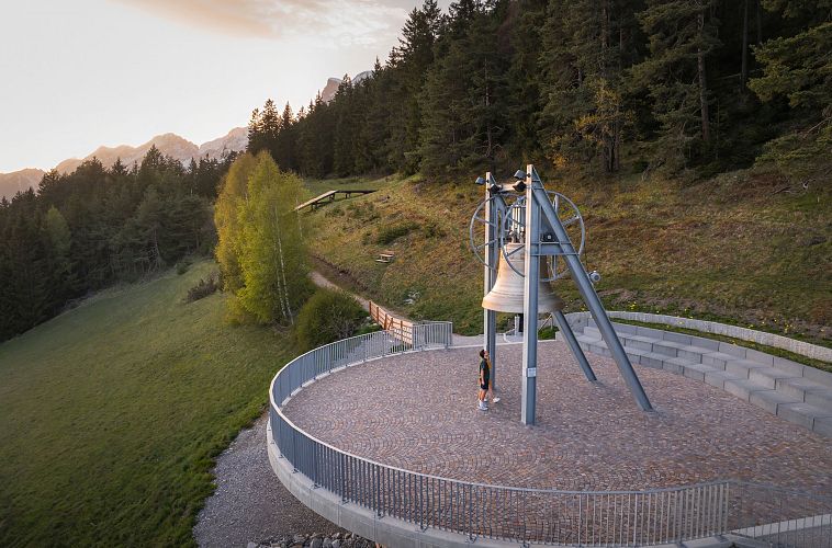 Friedensglocke Mösern zur Sonnenuntergangsstimmung im Frühling - Drohnenaufnahme Paar unterhalb der Glocke (4)