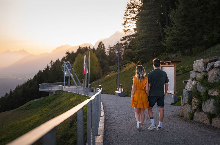Paar geht einen Weg in den Bergen bei Sonnenuntergang.