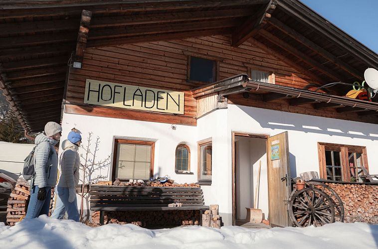 Hofladenrunde im Winter_zwei Frauen bei Thoamlhof laufen zum Hofladen