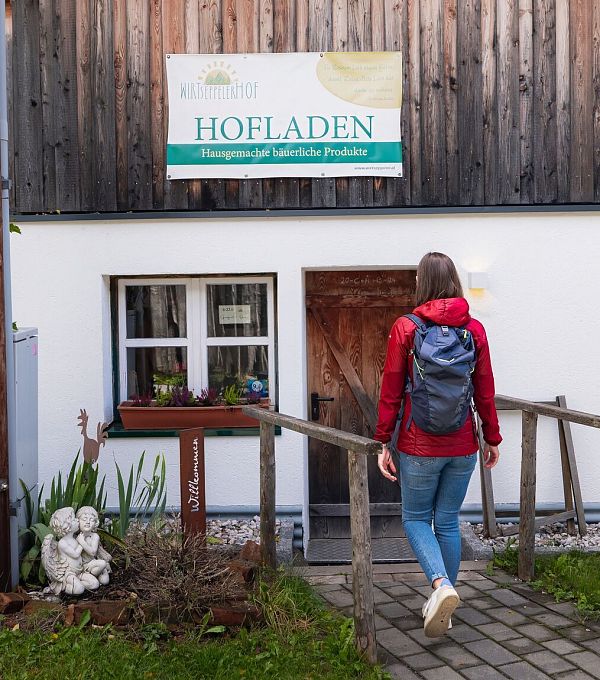 Hofladenrunde Leutasch - Frau geht auf Hofladen Wirtseppelerhof zu