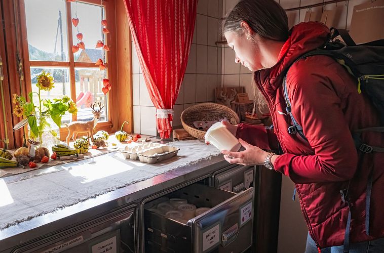 Hofladenrunde Leutasch - Frau schaut sich Joghurt an im Hofladen Thoamlhof