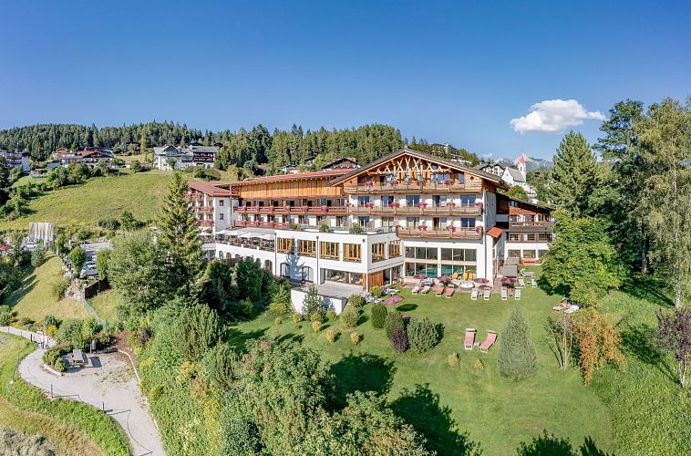 Ein Hotel inmitten einer grünen Landschaft mit blauem Himmel im Hintergrund.