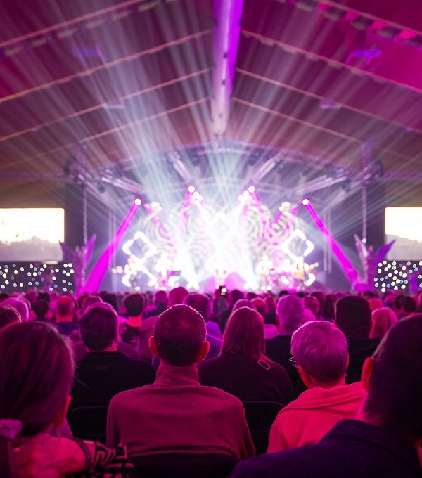Kastelruther Spatzen Konzert Publikum im Fokus viele Scheinwerfer mit Paar rechts unten