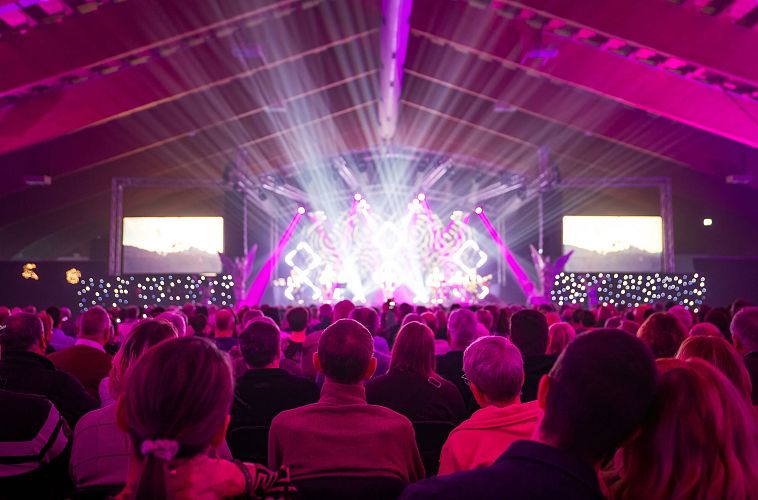 Kastelruther Spatzen Konzert Publikum im Fokus viele Scheinwerfer mit Paar rechts unten