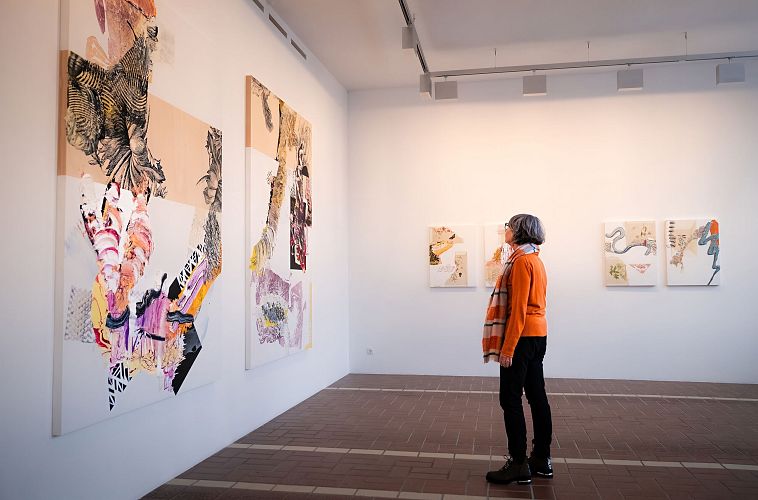 Kunst in Seefeld - Frau steht vor zwei großen Gemälden