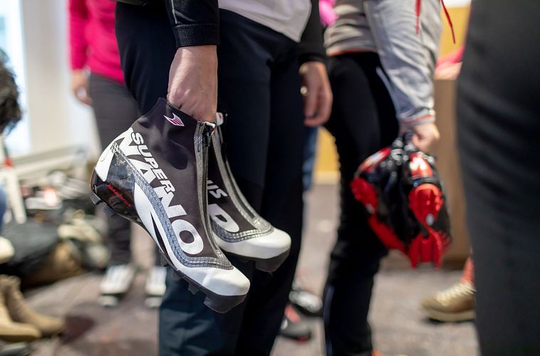 Personen halten Skischuhe in einem Raum. Vorbereitung für Wintersport-Aktivität in der Region Seefeld.