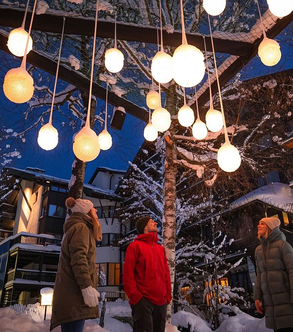 Lichterpark Seefeld drei Menschen schauen auf Lichterkugelinstallation