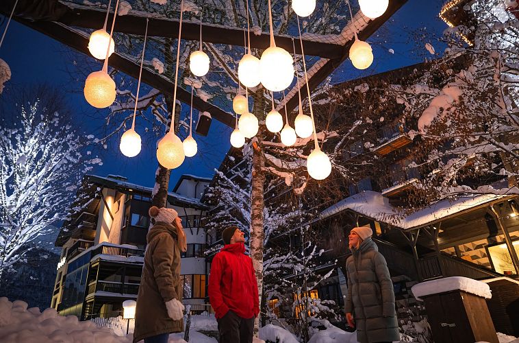 Lichterpark Seefeld drei Menschen schauen auf Lichterkugelinstallation