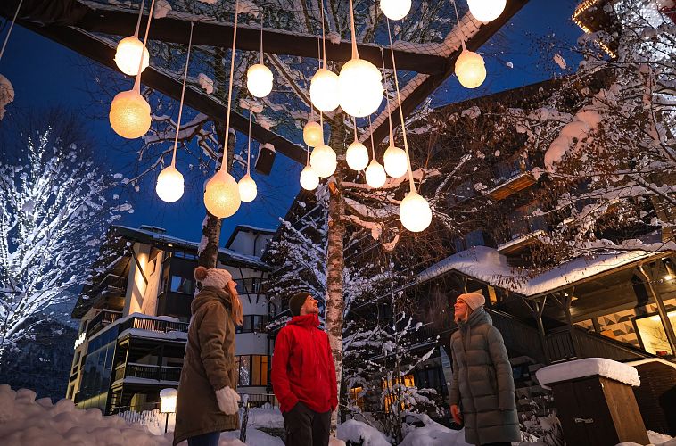 Lichterpark Seefeld drei Menschen schauen auf Lichterkugelinstallation