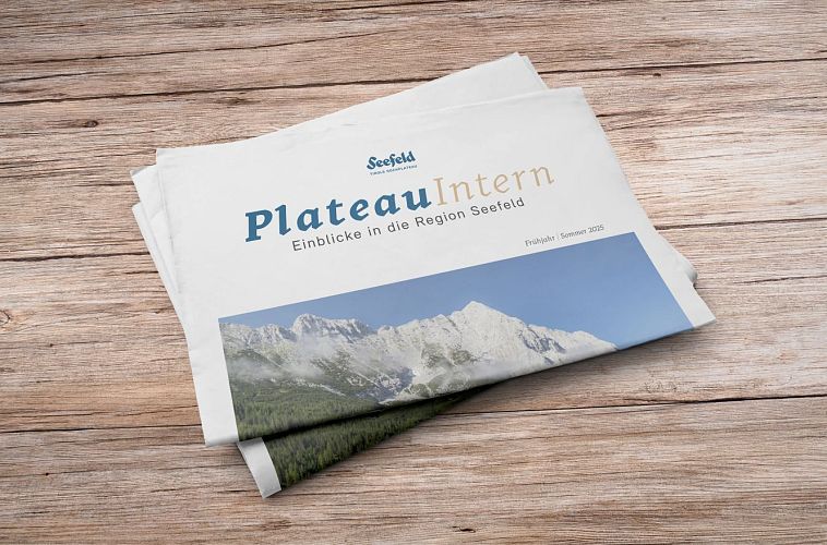 Zeitung Plateau Intern auf Holztisch, mit Titelbild der Region Seefeld.