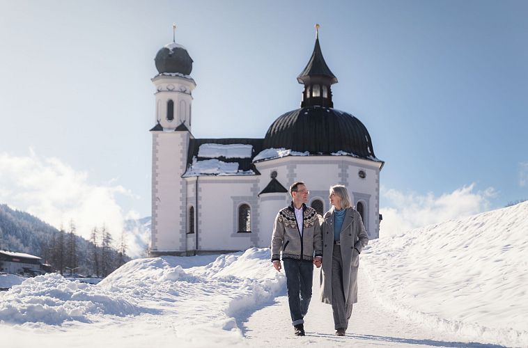 Paar auf Winter-Spaziergang durch Seefeld_Paar auf Weg vor Seekirchl