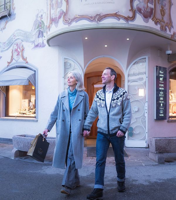 Ein Paar geht in einer dekorativen Einkaufsstraße. Keywords: Einkaufen, Spaziergang