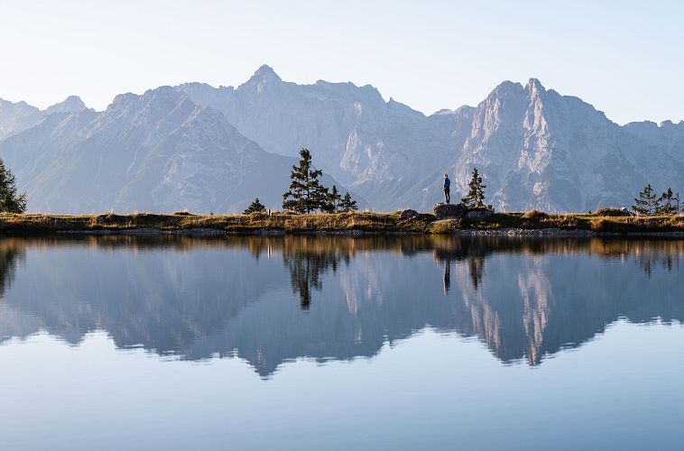 person-steht-auf-einem-stein-am-kaltwassersee-mit-blick-richtung-gehrenspitze-und-oefelekopf-2