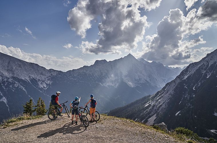 Radfahrer bei der Auffahrt zur Rotmoosalm - Pause mit Blick auf die Berge (1)