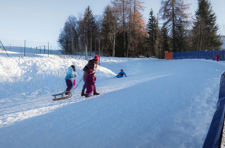 Rodelhügel Seefeld_Familie läuft den Hügel hinauf