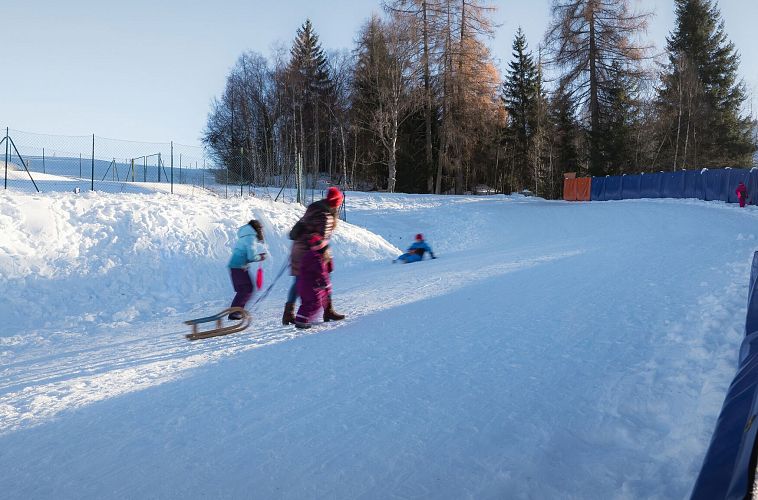 rodelhuegel-seefeld-familie-laeuft-den-huegel-hinauf