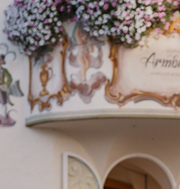 Paar spaziert durch malerische, blumengeschmückte Straße in der Region Seefeld.