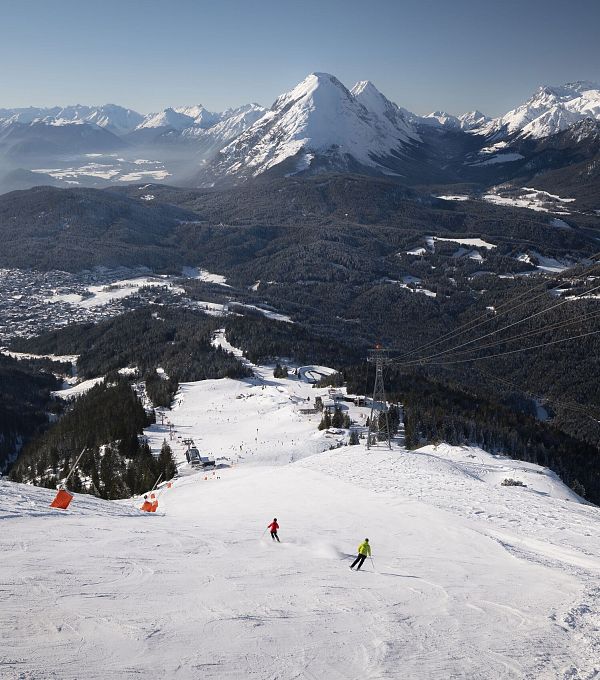 skifahrerin-an-der-rosshuette-zwei-skifahrerinnen-auf-abfahrt-von-der-bergstation-mit-blick-auf-hohe-munde-1