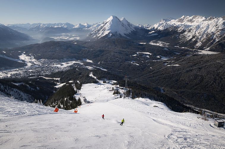 skifahrerin-an-der-rosshuette-zwei-skifahrerinnen-auf-abfahrt-von-der-bergstation-mit-blick-auf-hohe-munde