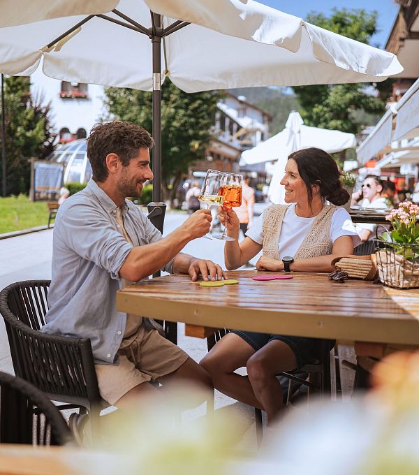 Sommerurlaub in der Region Seefeld - Paar genießt Drinks in der Fußgängerzone Seefeld