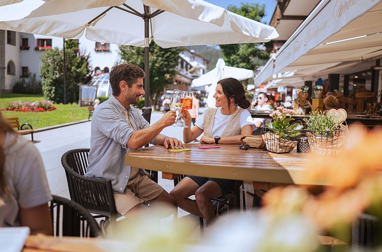 Sommerurlaub in der Region Seefeld - Paar genießt Drinks in der Fußgängerzone Seefeld