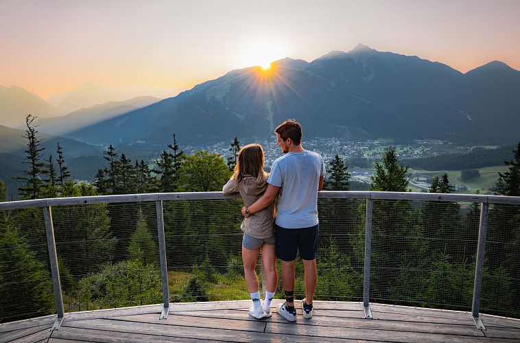 Sonnenaufgang Aussichtsplattform Bruschkopf - Paar steht am Geländer der Plattform - Aufnahme von hinten - Paar schaut sich an