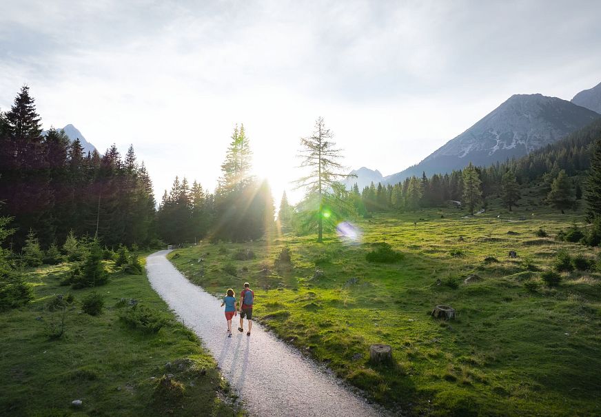 Drohnenaufnahme Wanderung im Gaistal im Sommer - Paar auf Wanderweg bei tiefstehender Sonne
