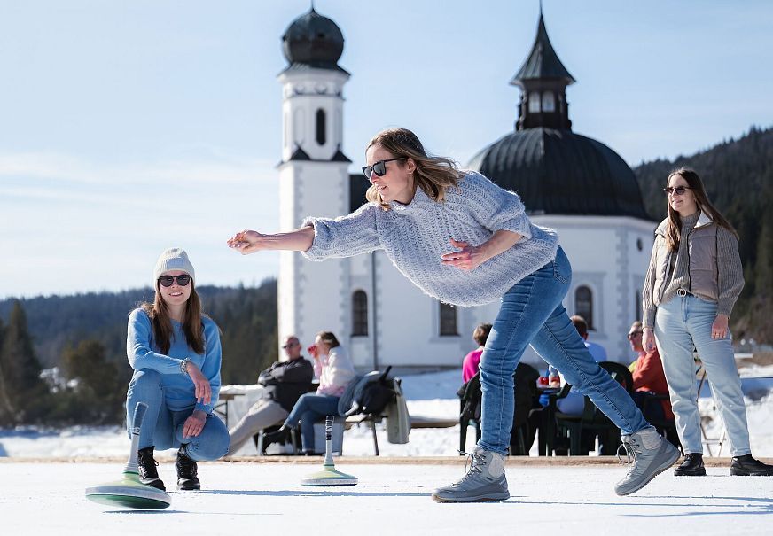 Eisstockschießen am Eislaufplatz in Seefeld_Frau im Wurf_Hochformat