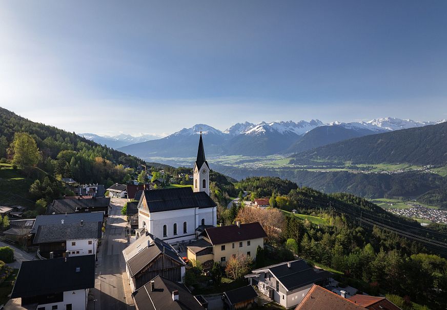 sub1-reith-im-fruehling-bei-morgenstimmung-drohnenaufnahme-kirche-mit-blick-ins-inntal