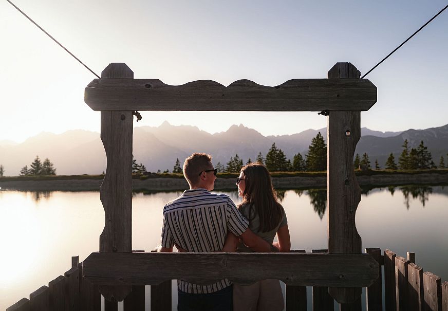 Sonnenuntergang am Kaltwassersee_Paar steht vor Bilderrahmen und schaut sich an