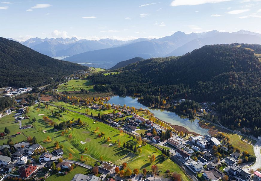 sub1-wildsee-im-herbst-drohnenaufnahme-blick-auf-golfplatz-und-see-mit-bergpanorama-1-1