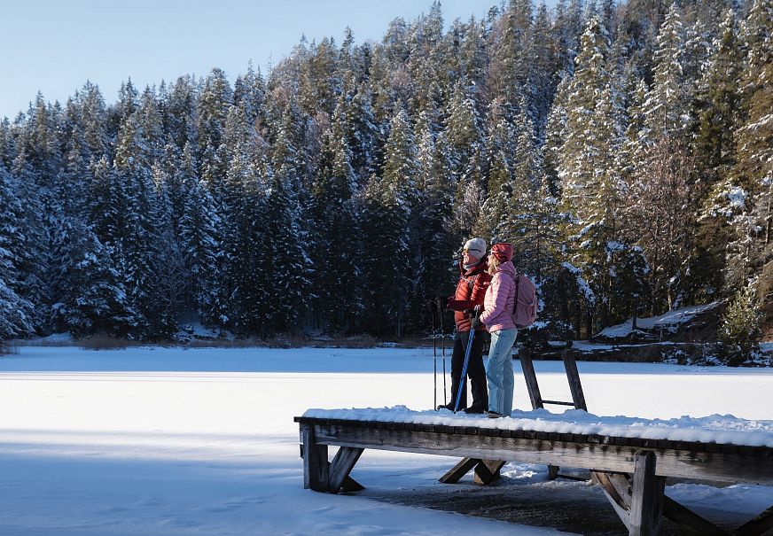 sub1-winterwandern-in-der-region-seefeld-mann-und-frau-am-moeserer-see-stehen-auf-steg-1